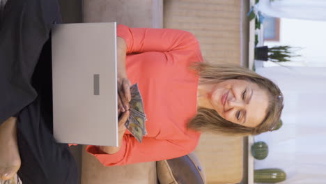 Vertical-video-of-Woman-looking-at-laptop-counting-money.